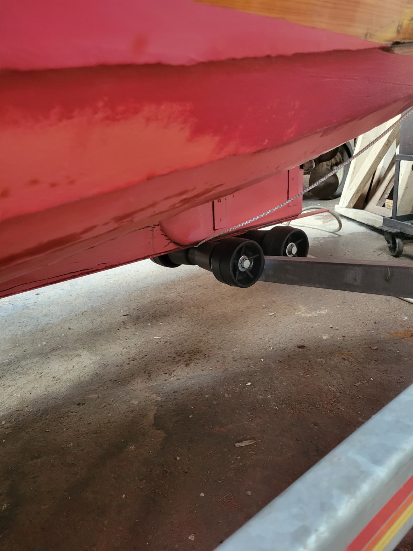 Rolling antifouling paint onto a boat hull on stands